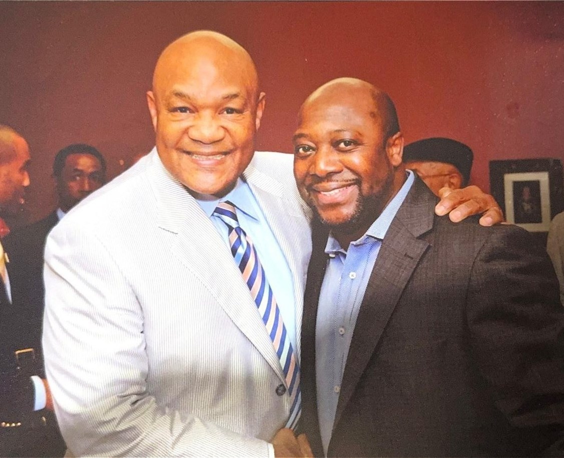 Cloyd Benjamin with George Foreman at a community gathering
